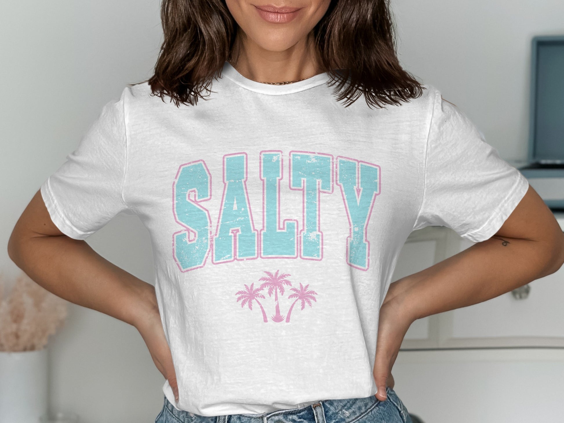 White t-shirt with "SALTY" text and palm trees graphic.