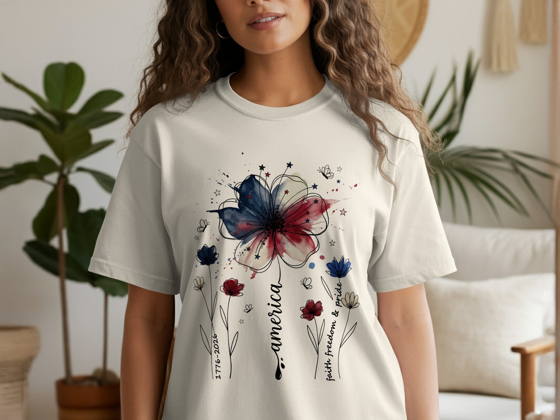T-shirt with watercolor floral America design and 1776-2026 text.