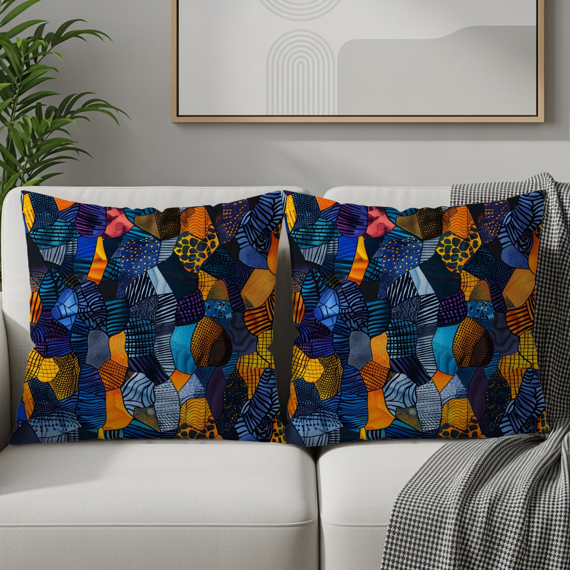 Two throw pillows with a colorful, abstract patchwork geometric pattern on a sofa.
