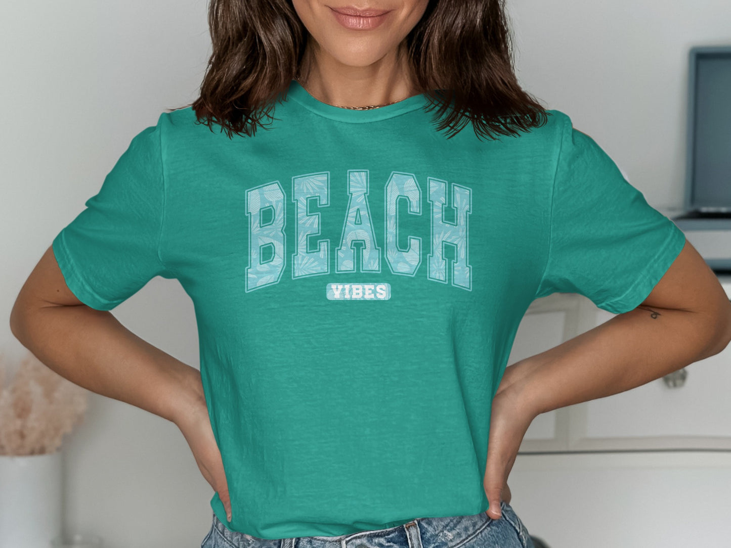 Teal t-shirt with "BEACH VIBES" text in white tropical leaves.