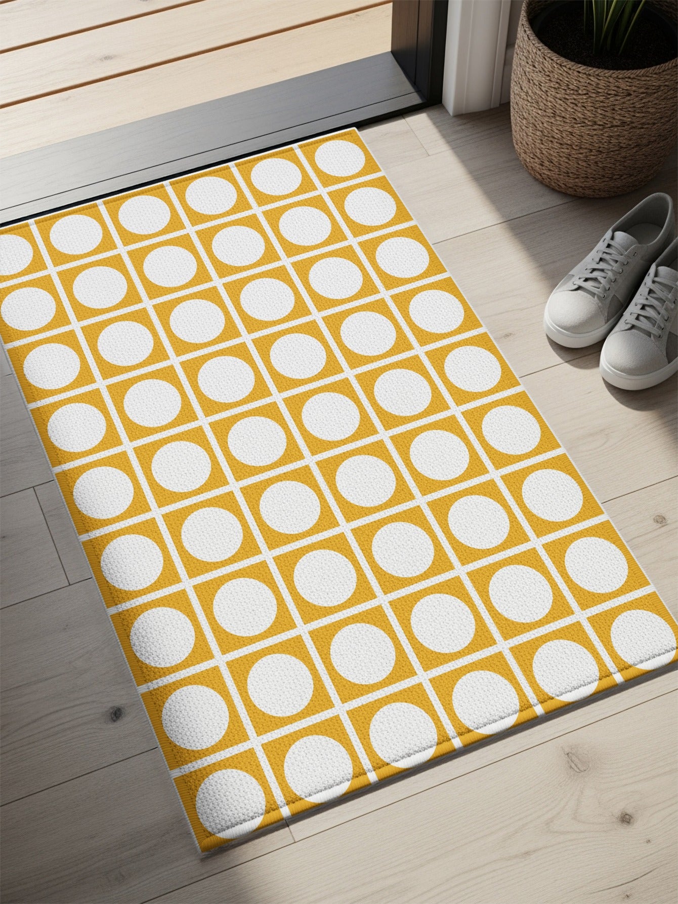 Yellow and white geometric doormat with repeating squares and circles pattern.