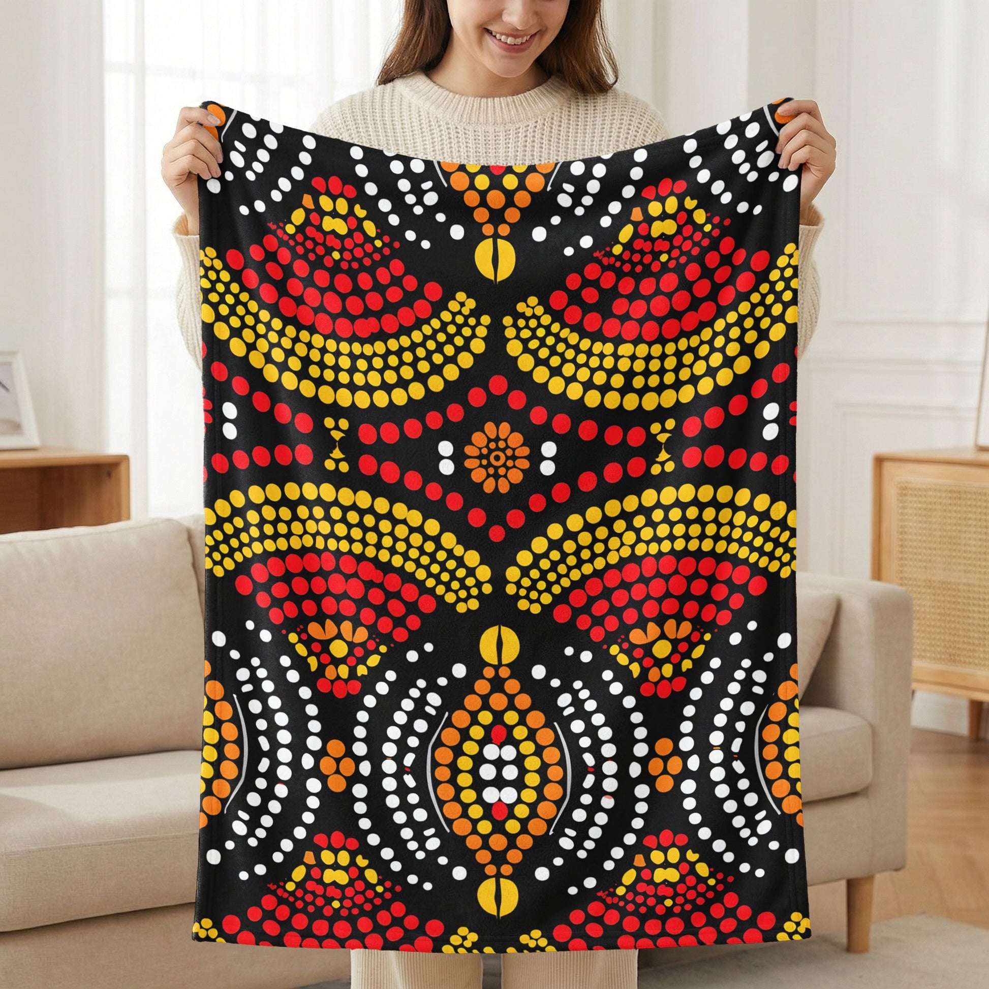Black blanket with red, yellow, and white dot art geometric pattern.