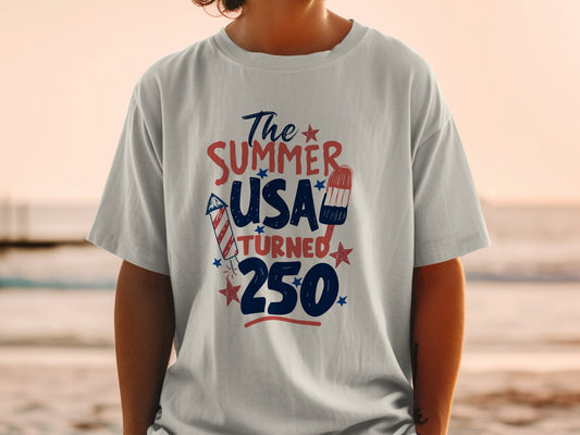 T-shirt with "The Summer USA Turned 250" text and patriotic graphics.