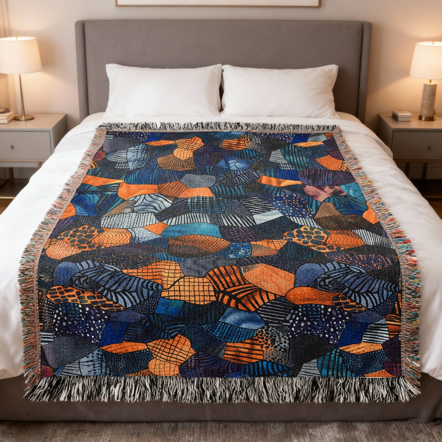 Woven throw blanket with abstract geometric pattern in blue, orange, and black.