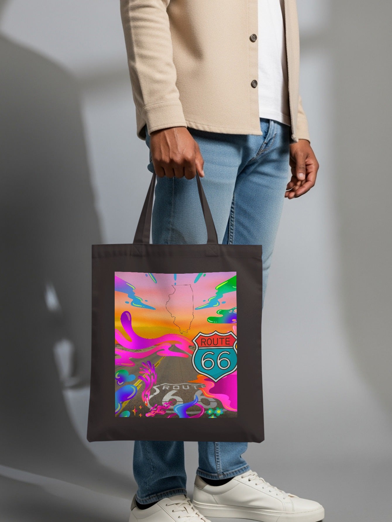 Dark tote bag with vibrant Route 66 graphic held by a person.