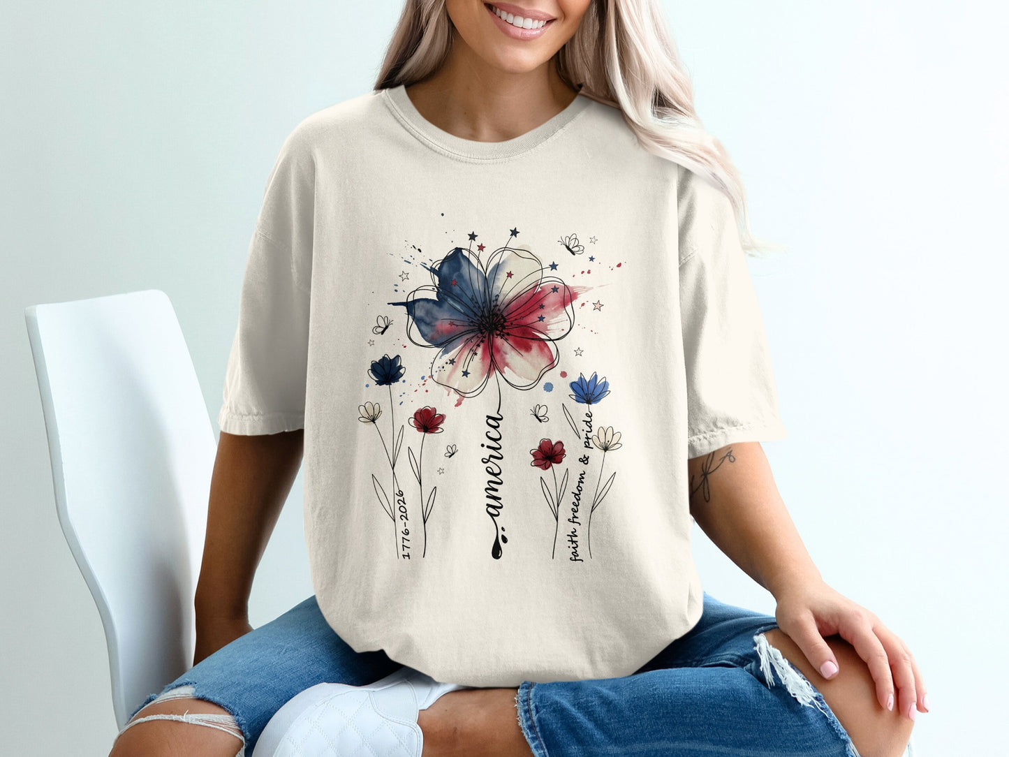 Cream t-shirt with patriotic floral design and text "faith, freedom, pride".