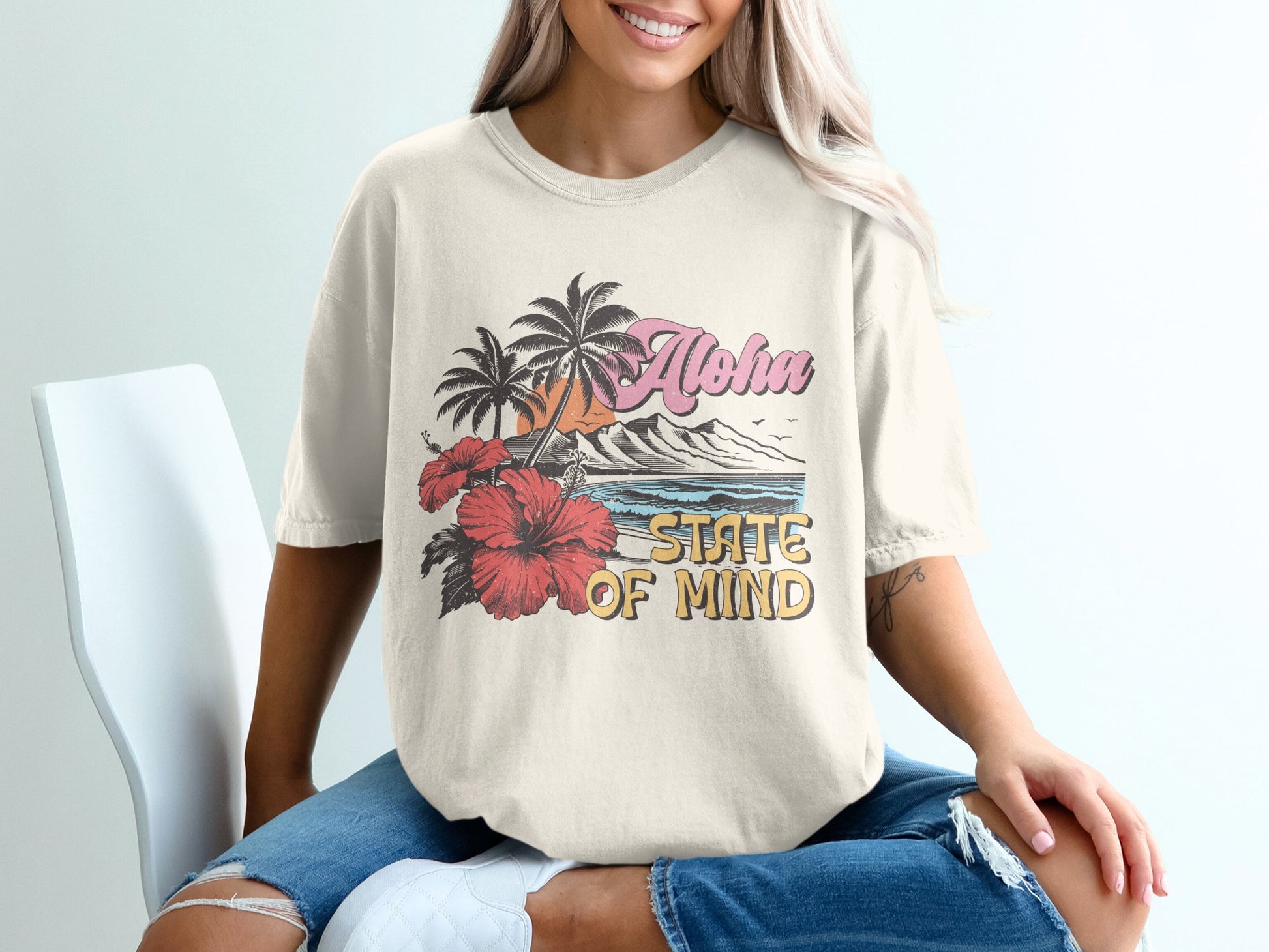 Cream t-shirt with "Aloha State of Mind" graphic featuring hibiscus and palm trees.
