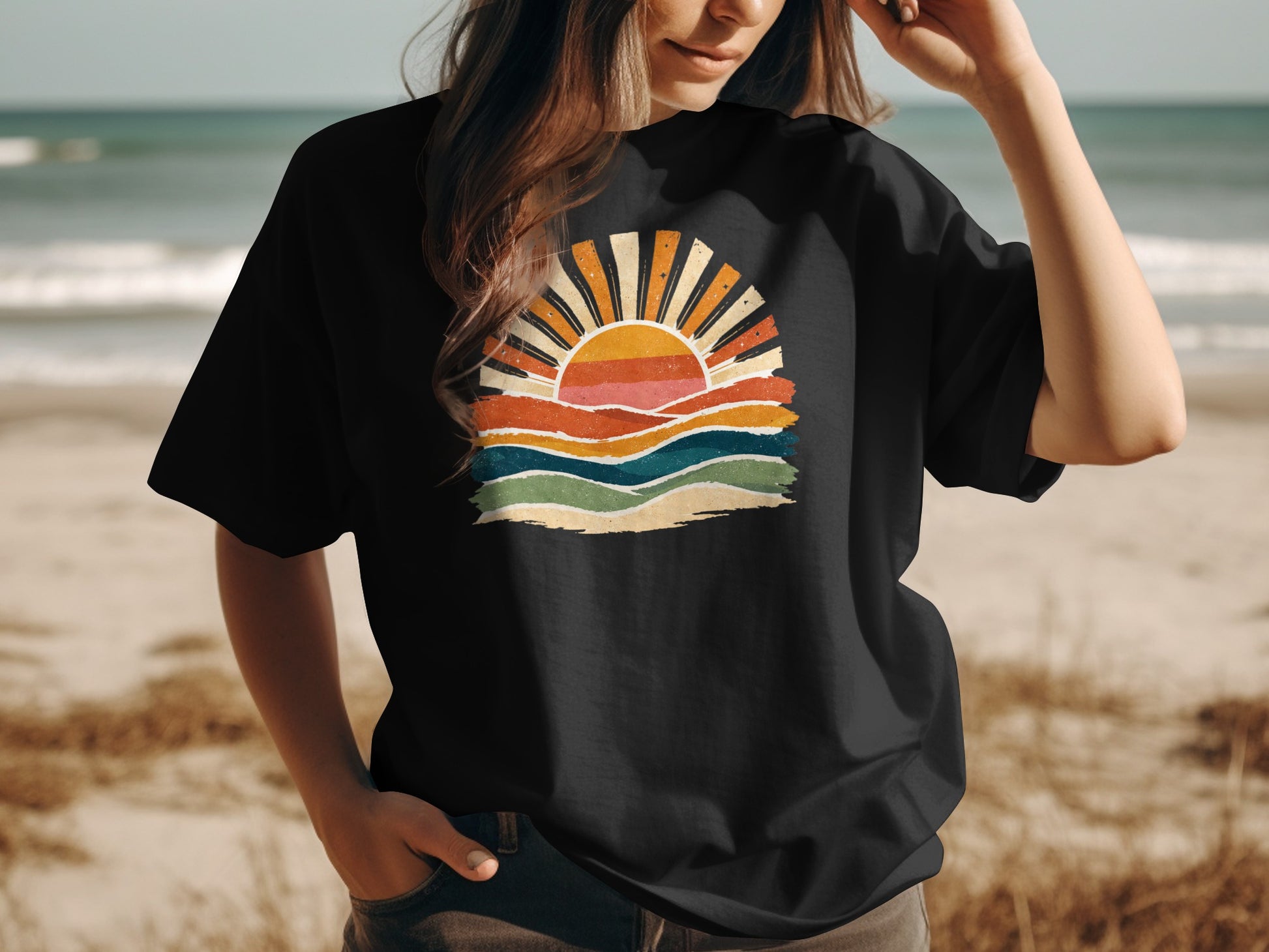Black t-shirt with retro sunset graphic and waves on a beach.
