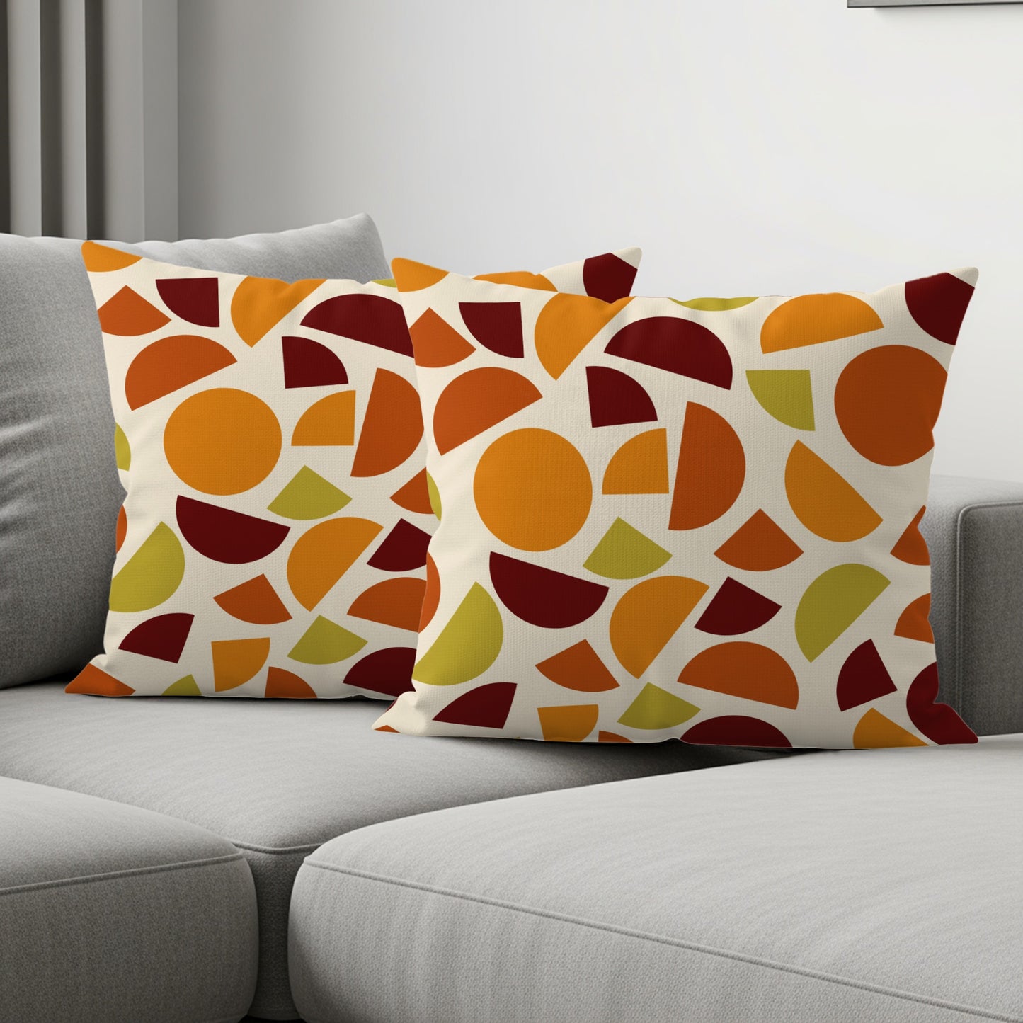 Two throw pillows with a geometric pattern of circles and semicircles in warm colors.