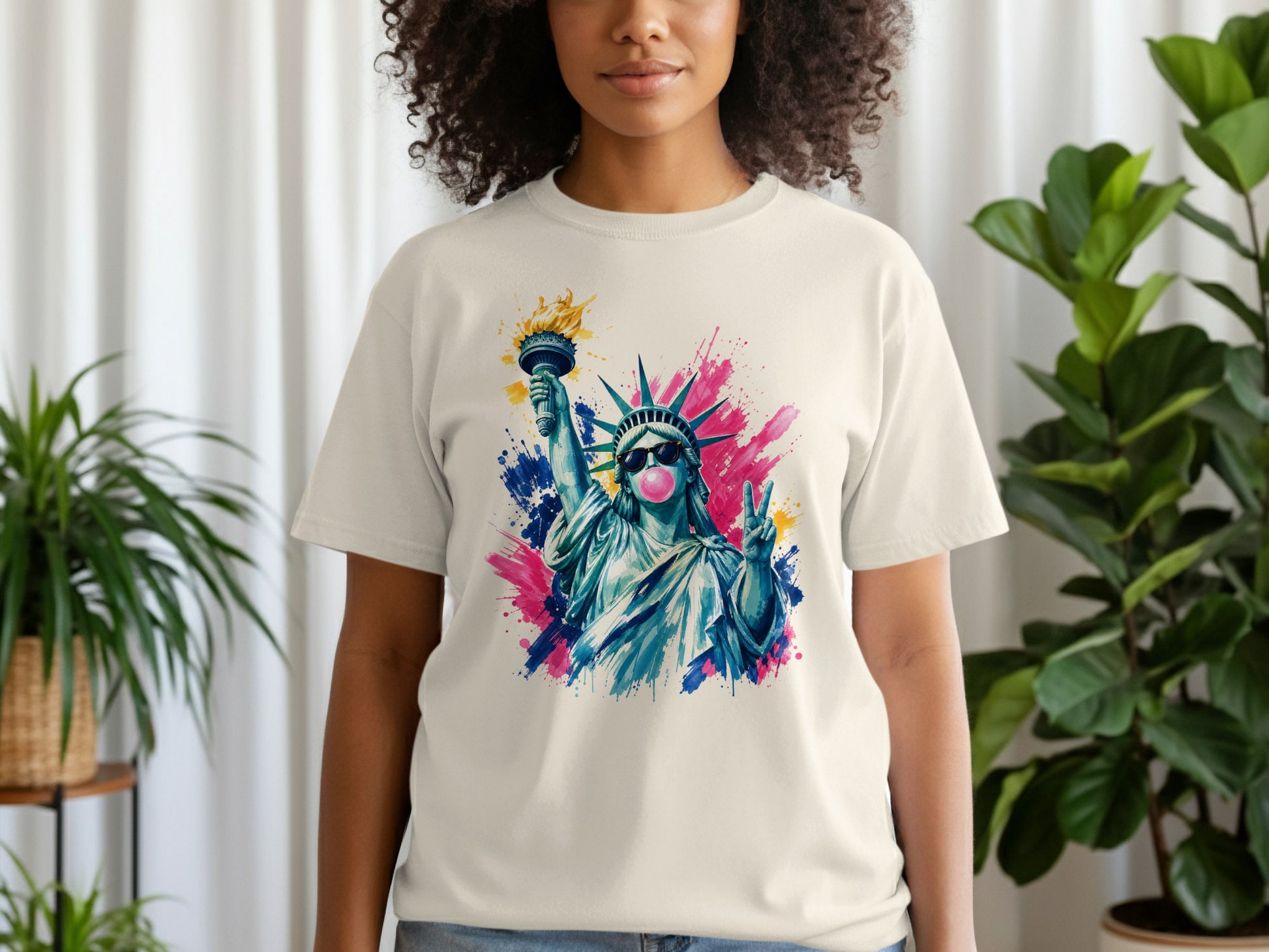 Statue of Liberty blowing pink bubble gum, wearing sunglasses, on a light t-shirt.