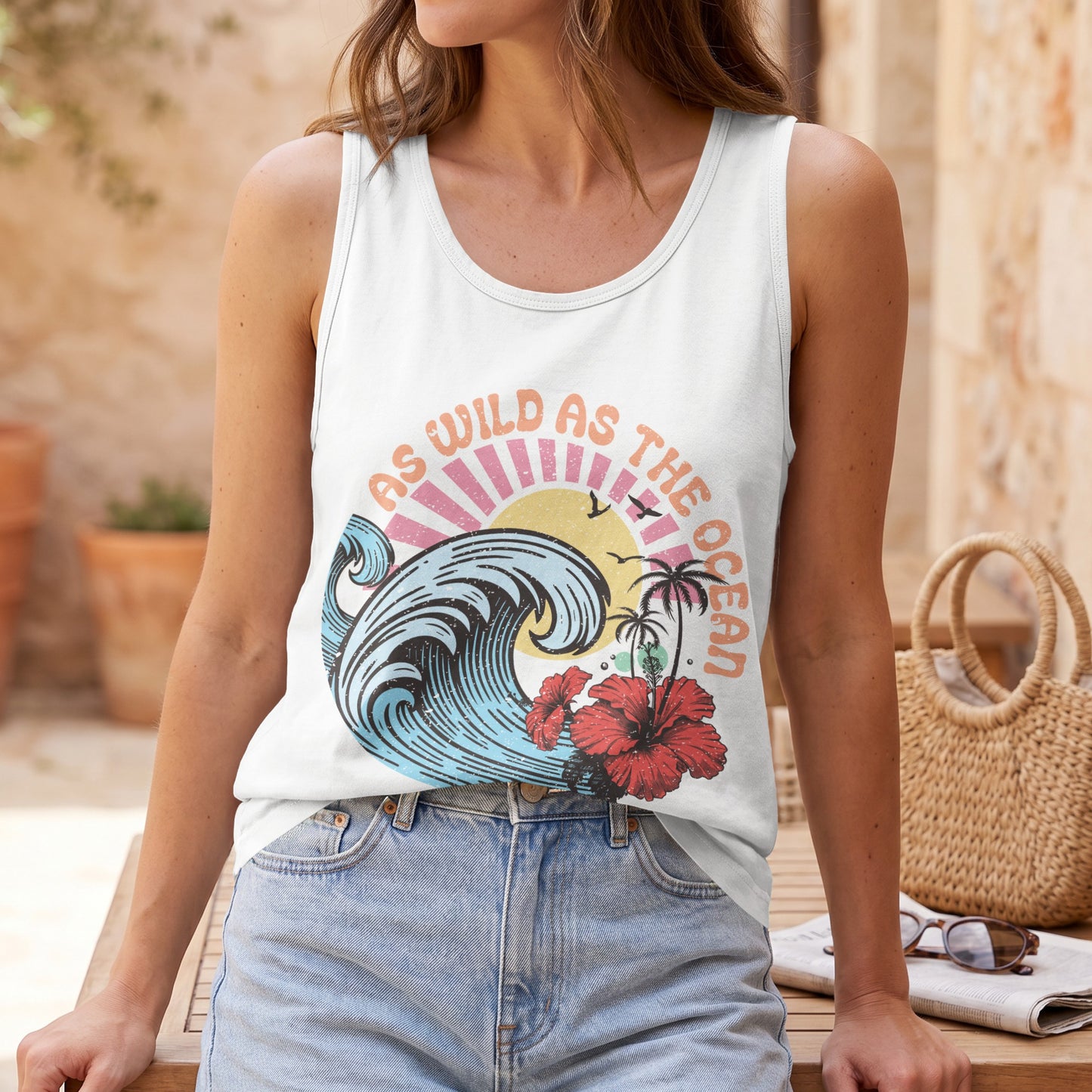 White tank top with "As Wild As The Ocean" wave graphic and hibiscus.