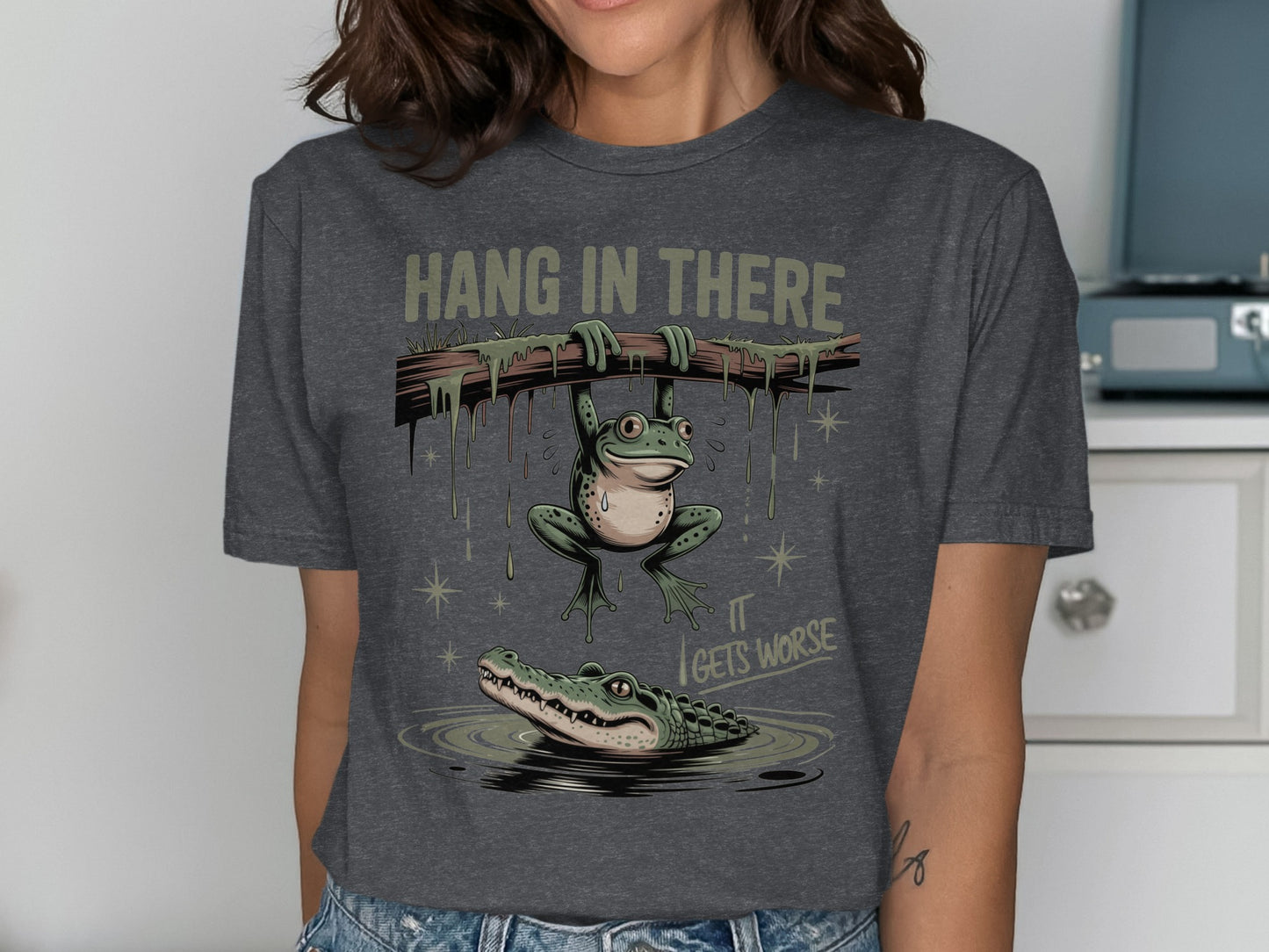 Frog hanging from branch above alligator with text "Hang in there it gets worse".