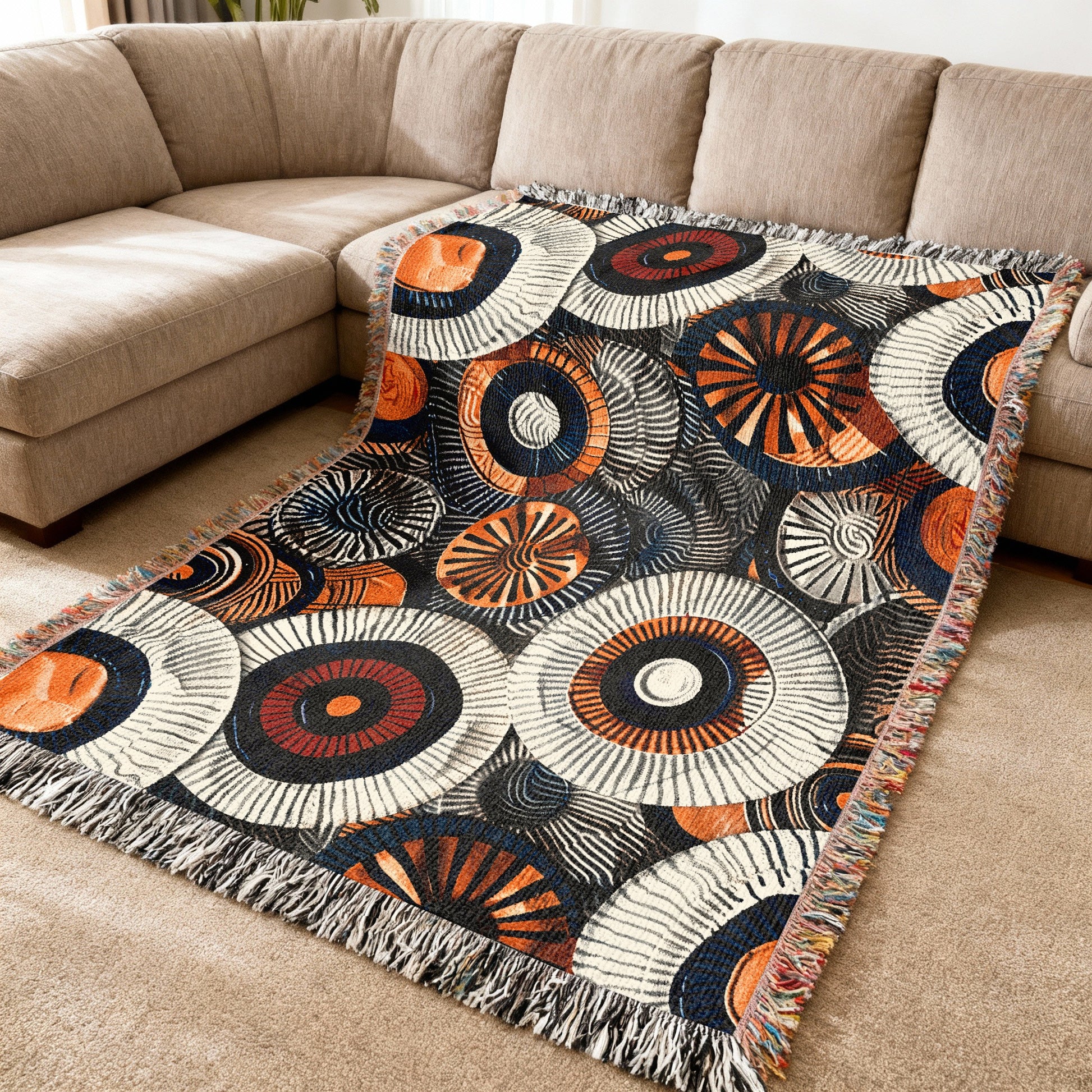 Throw blanket with segmented circle pattern in orange, white, navy, and red.