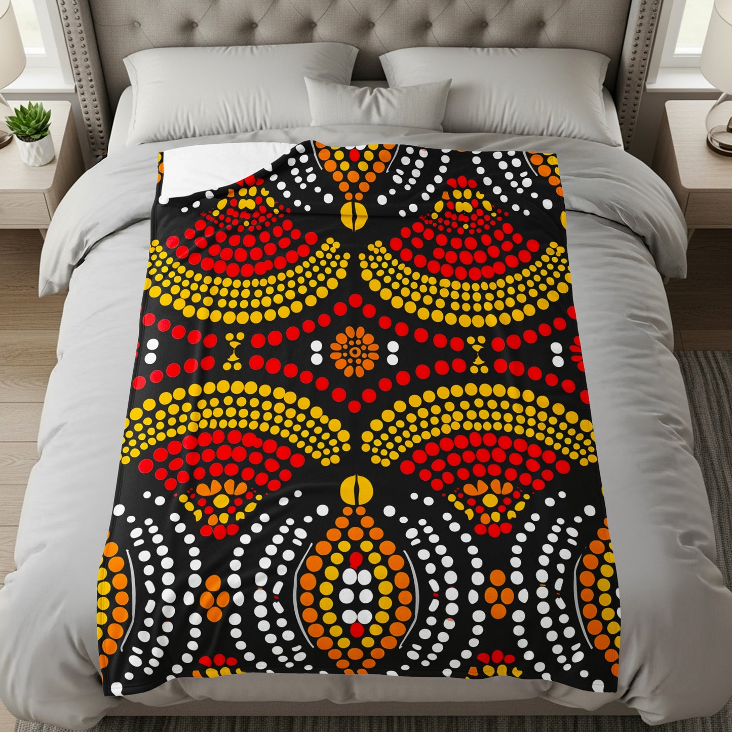Black blanket with red, yellow, and white dot art pattern.