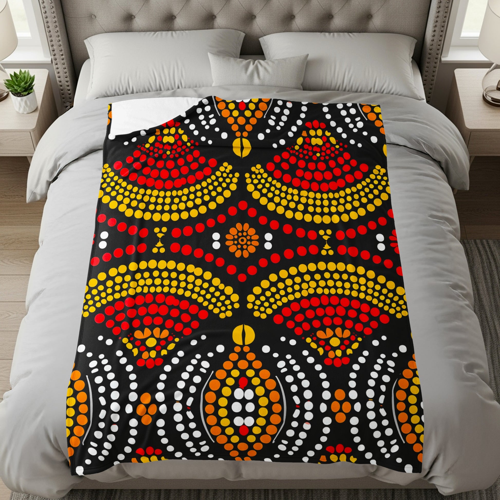 Black blanket with red, yellow, and white dot art pattern.