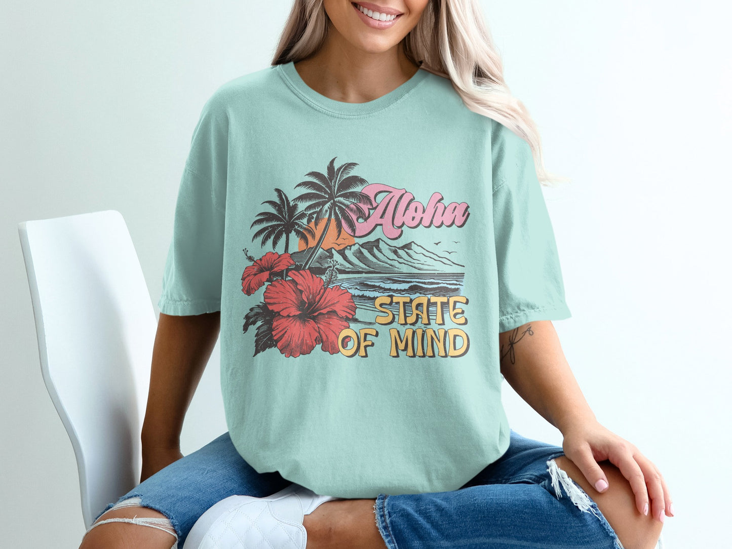 Light blue t-shirt with "Aloha State of Mind" text and tropical beach scene.