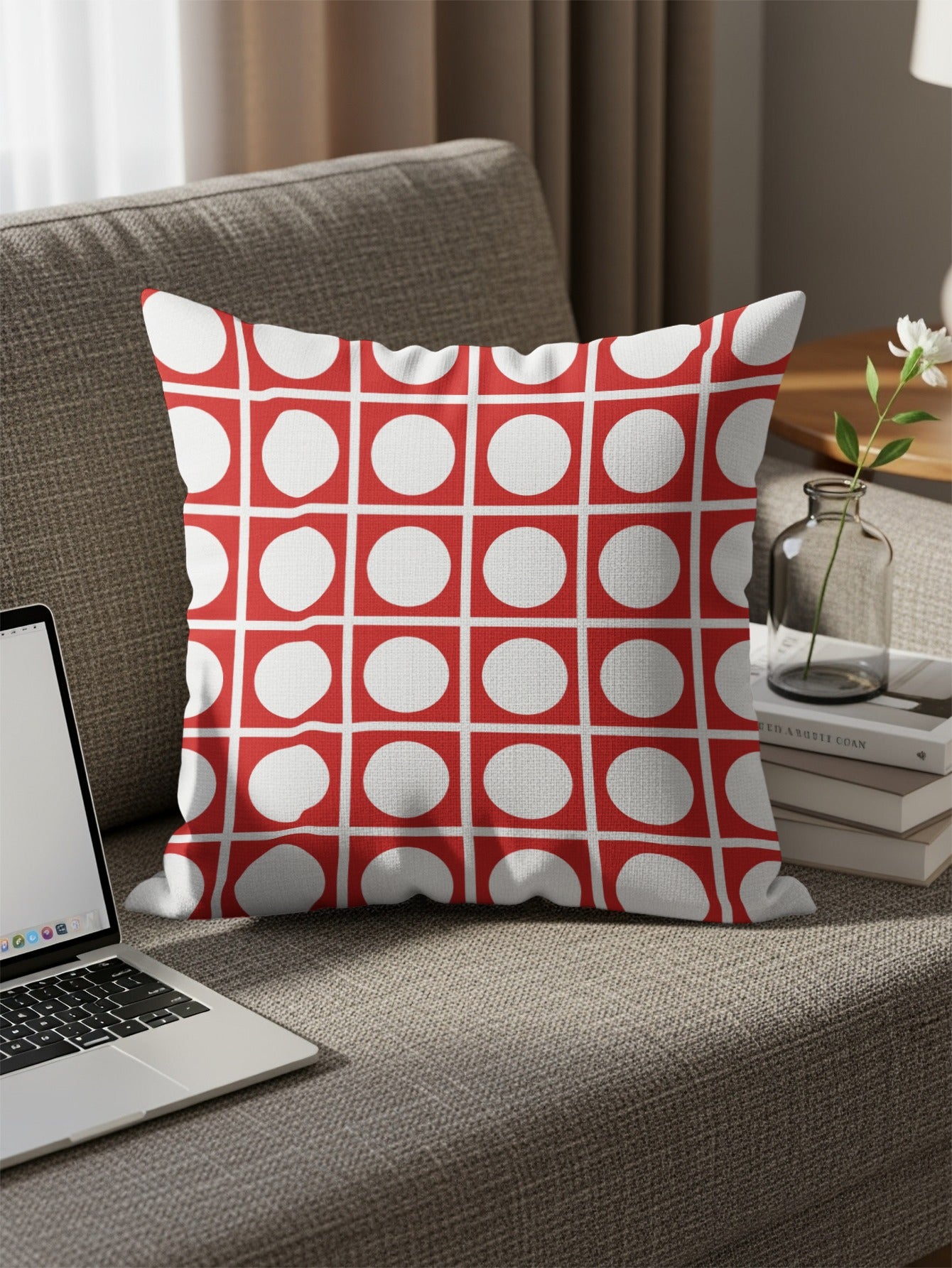Red and white throw pillow with square grid of circles on a sofa.