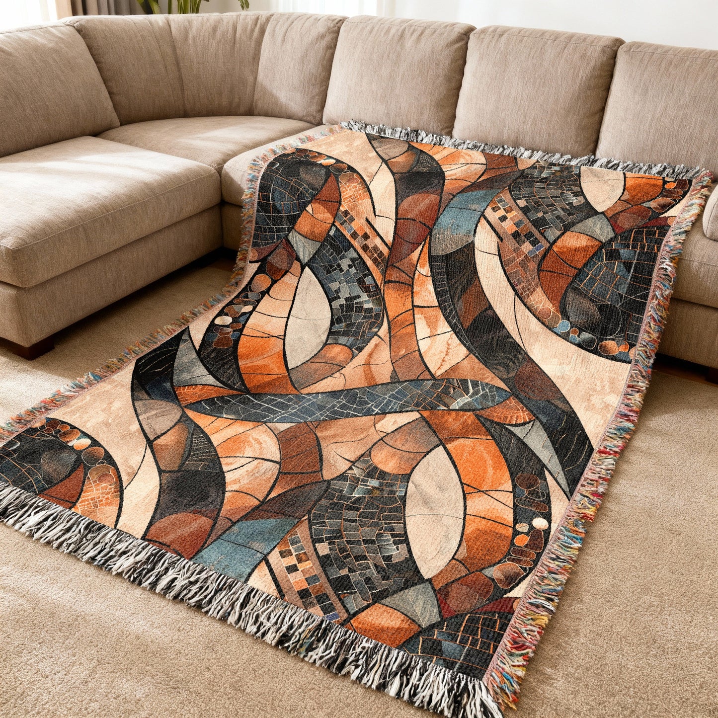 Woven throw blanket with abstract mosaic pattern in warm earthy tones and fringe.