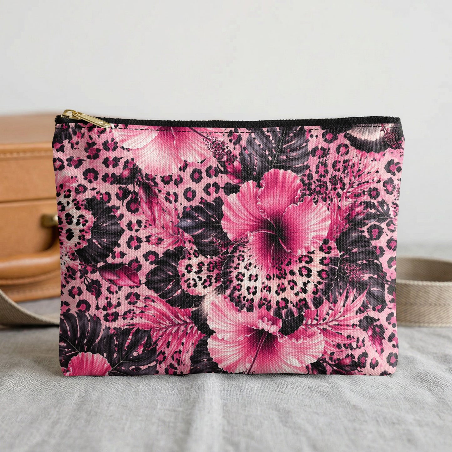 Pink leopard print cosmetic bag with tropical floral pattern and gold zipper.