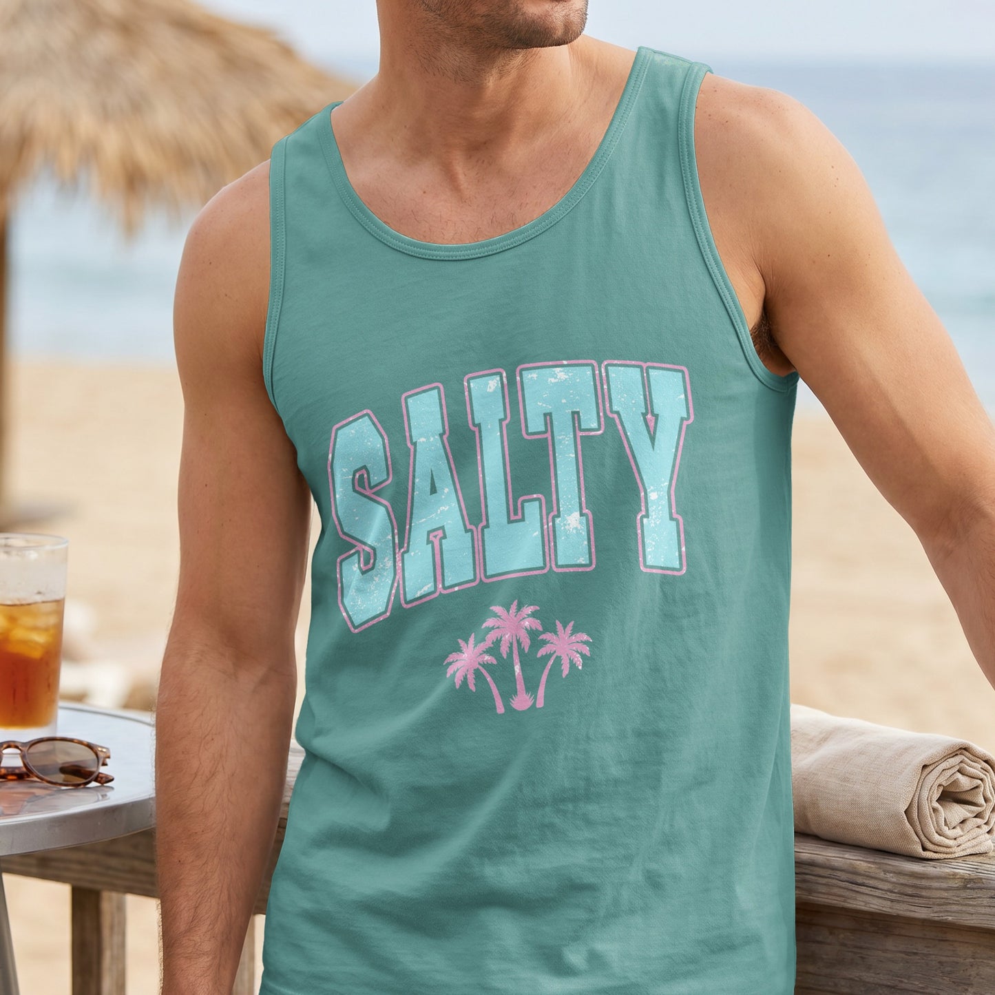 Teal tank top with "SALTY" text and palm trees, worn by a man.