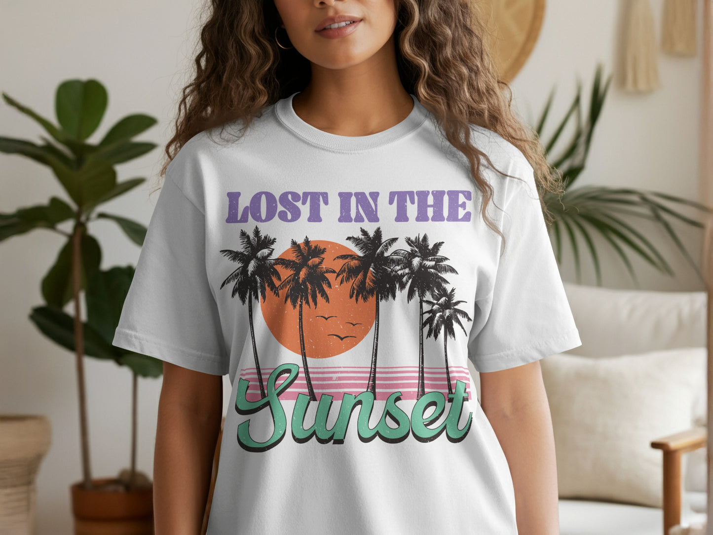 White t-shirt with "LOST IN THE Sunset" graphic featuring palm trees and a sunset.