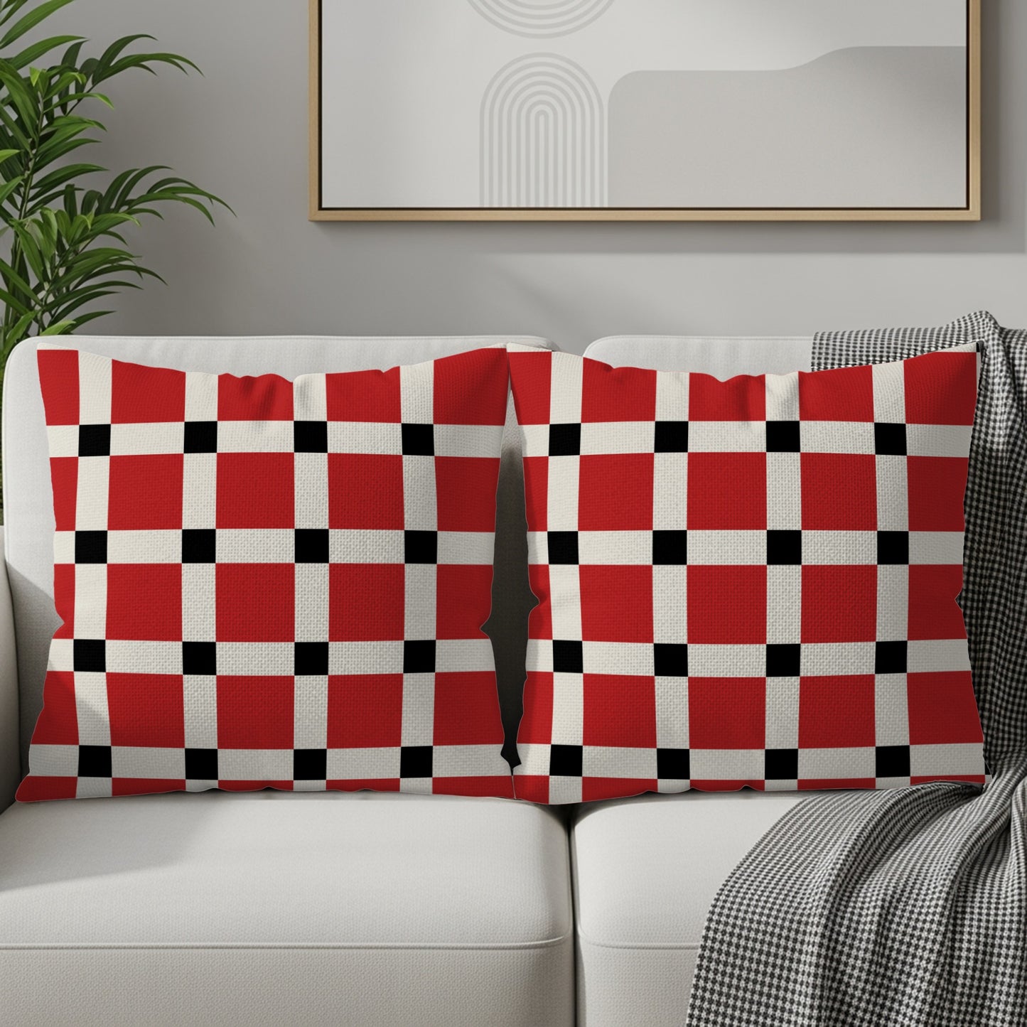 Two couch pillows with a red, white, and black checkerboard pattern.