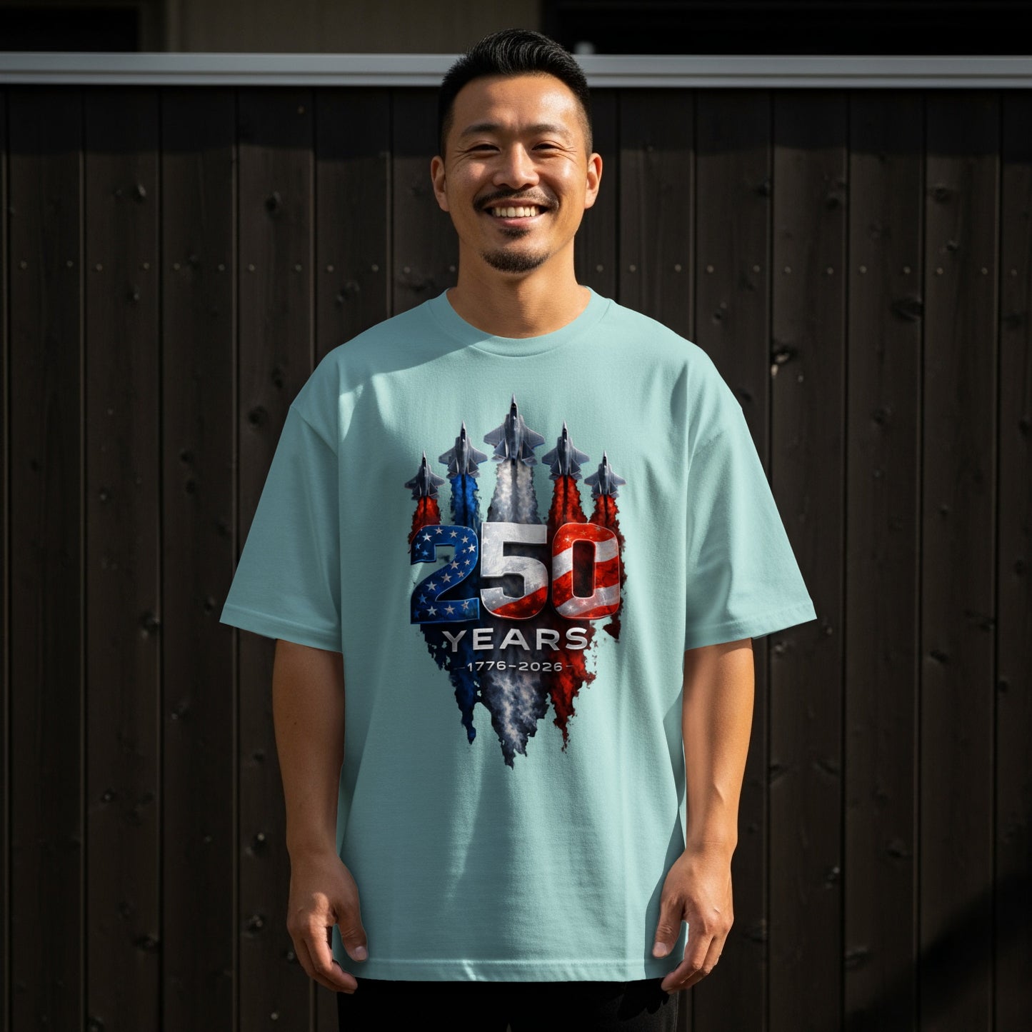 Man wearing light blue t-shirt with "250 1776-2026" patriotic graphic.