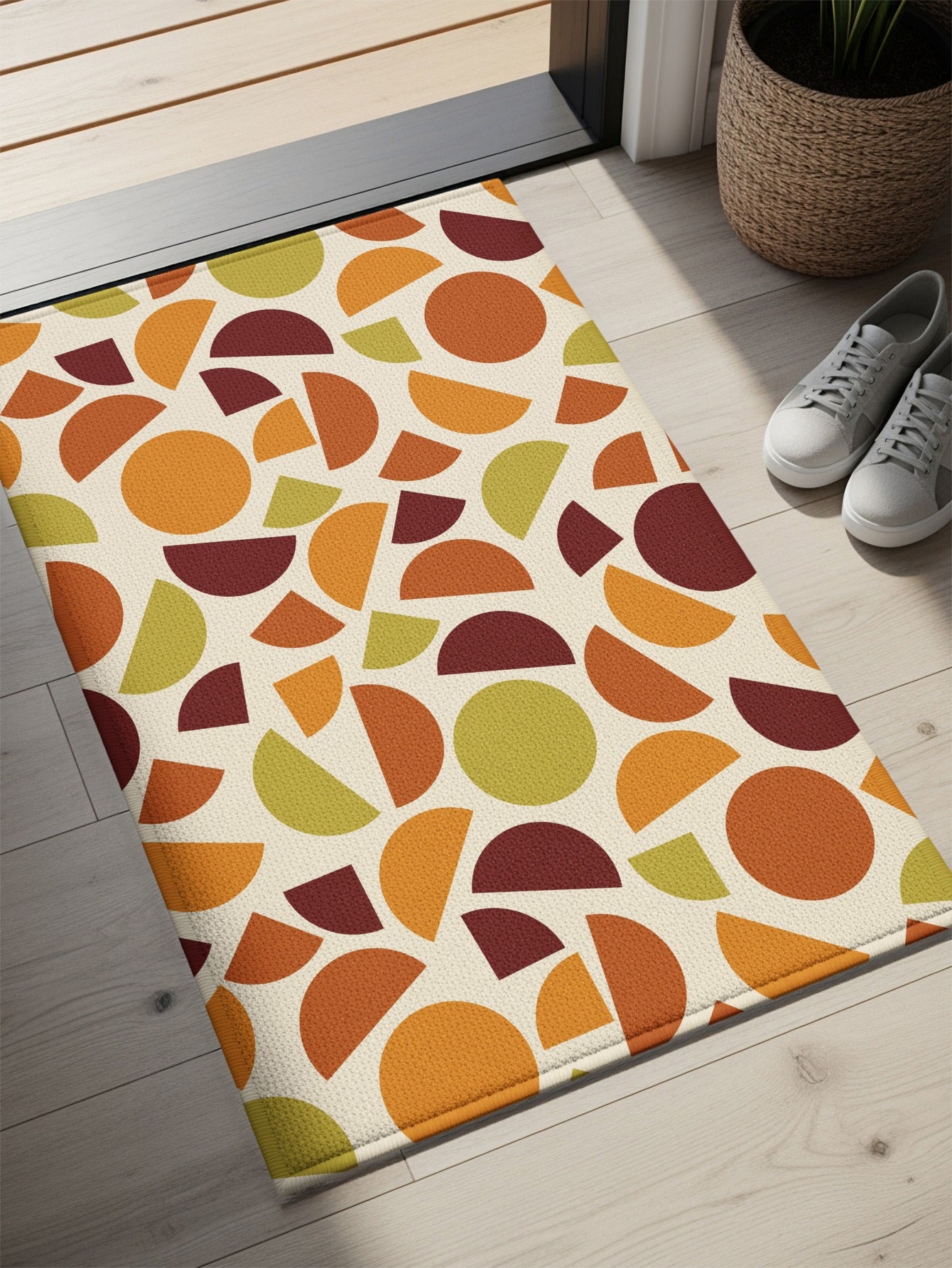 Doormat with geometric pattern of circles and semicircles in orange, green, and burgundy.